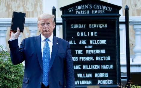 Donald Trump holding a Bible, backward--which perhaps is a fitting metaphor for the hypocritical white conservative "Christians,