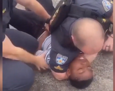 Thuggish Baton Rouge police officer shown above choking 13-year-old Black boy--while another officer holds the boy.