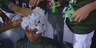 video of players sticking a cotton like material on a Black teammate's head